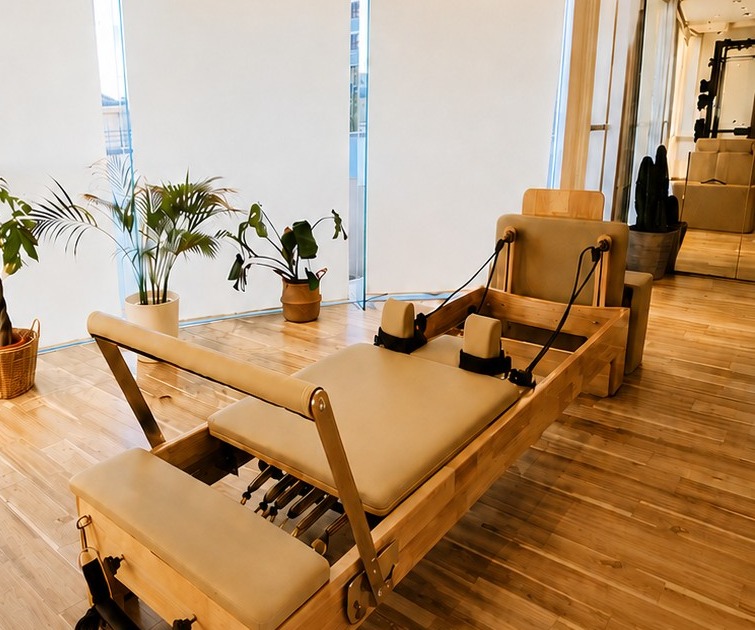 Body Design Studio PIECEの店内。木目の床にリフォーマーが並ぶスタジオ。